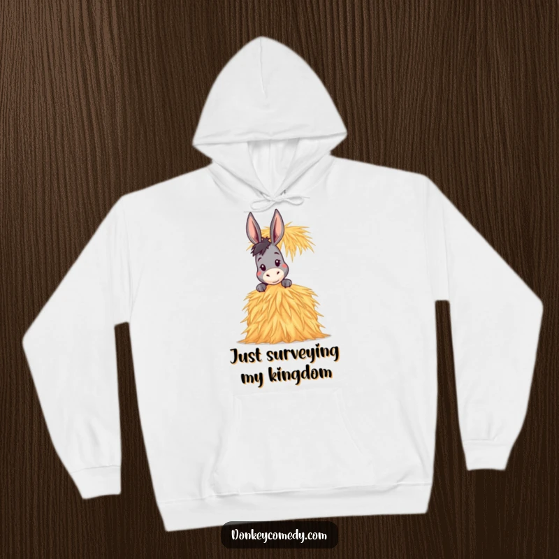 Funny Donkey Hoodie illustrating a donkey peeking over a massive, humorous stack of hay, conveying playful curiosity and warmth.