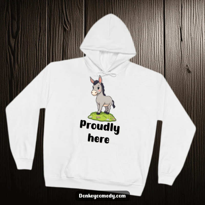 Funny proud donkey standing on a grassy mound, featured on a warm hoodie, a humorous and comfortable gift.